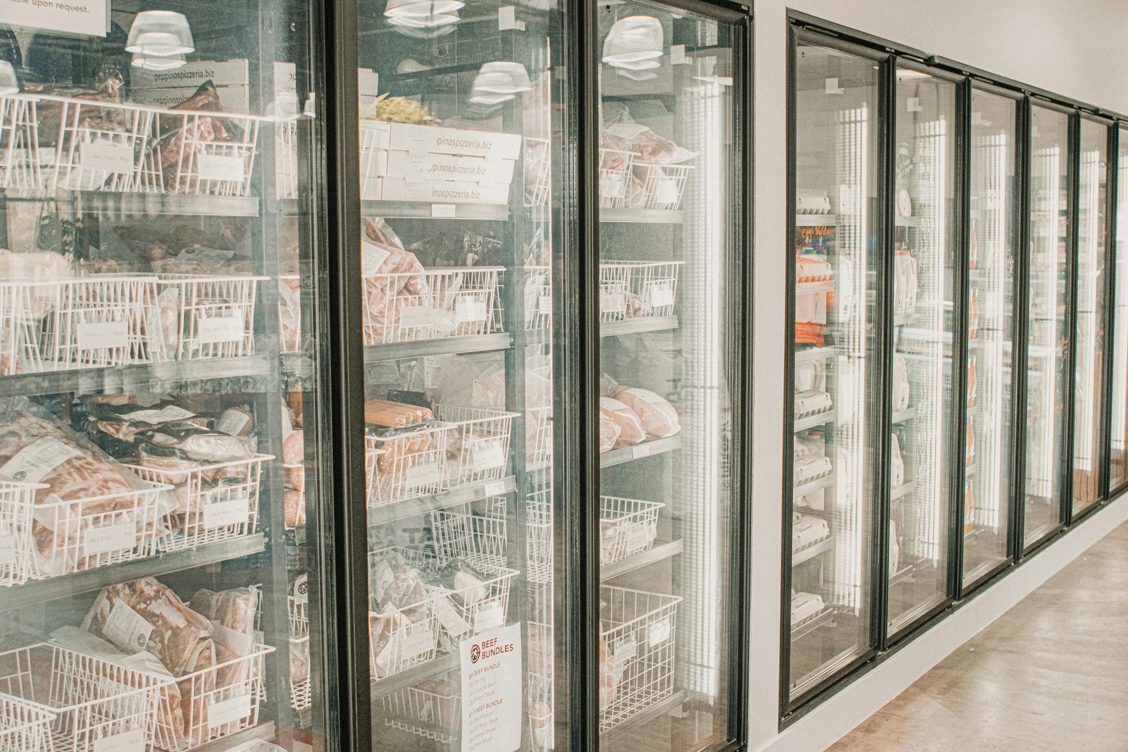 Row of refrigerated display cabinets in a commercial cold storage facility lit by overhead LED panels
