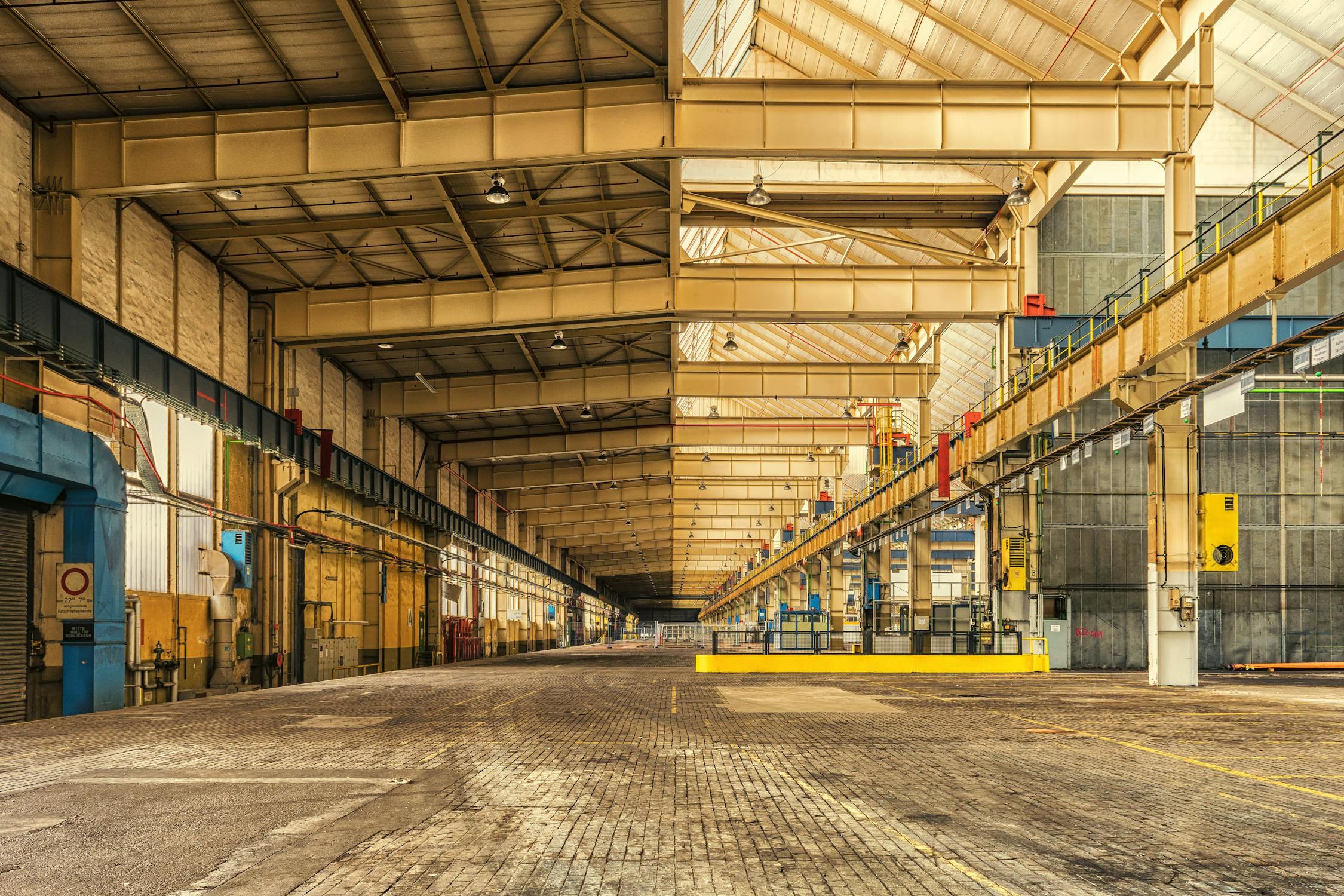 Expansive industrial warehouse interior with high bay lighting running the full length of the facility