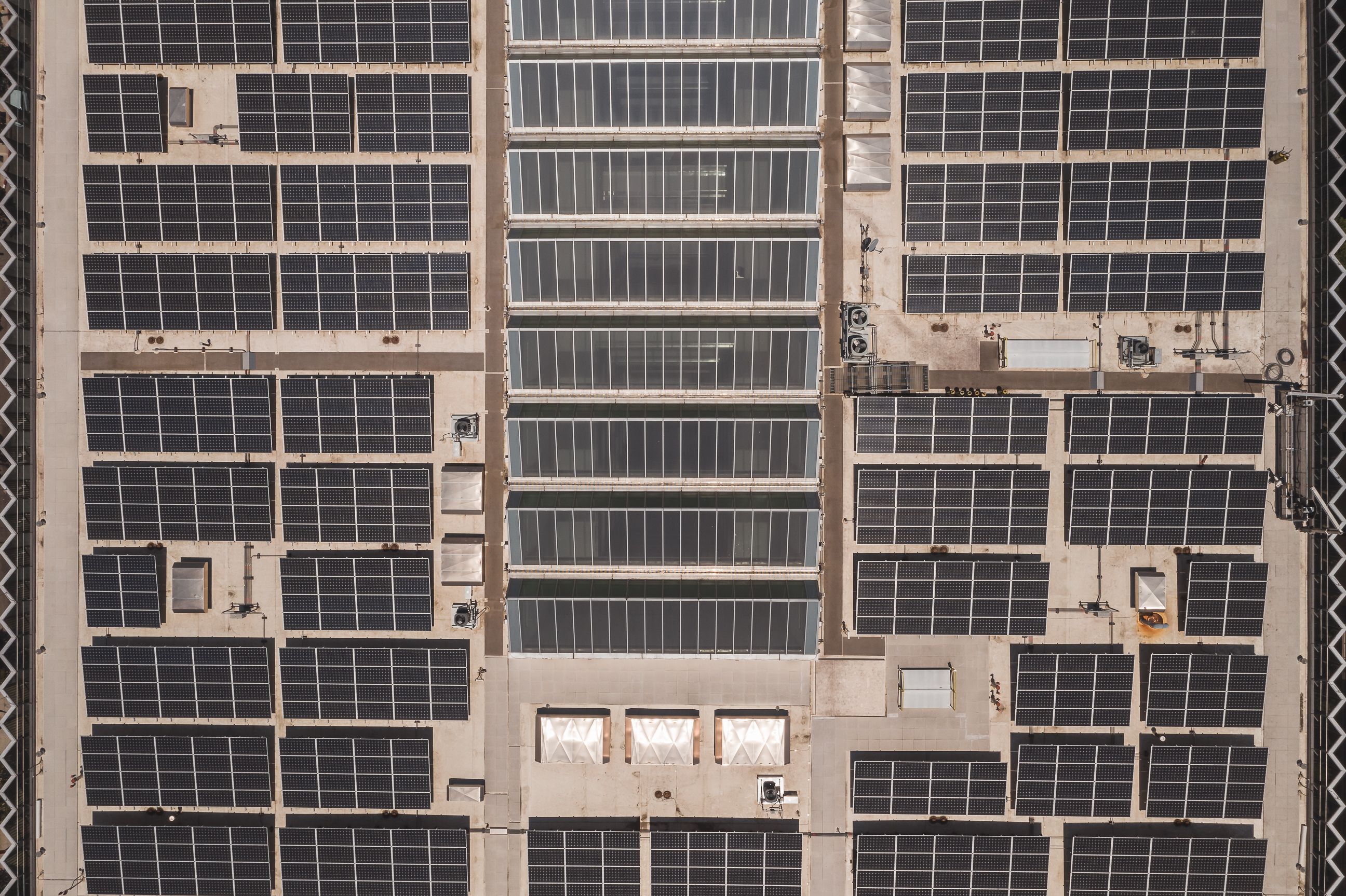 Aerial view of solar panels on an industrial rooftop — combined LED and solar ROI for commercial clients